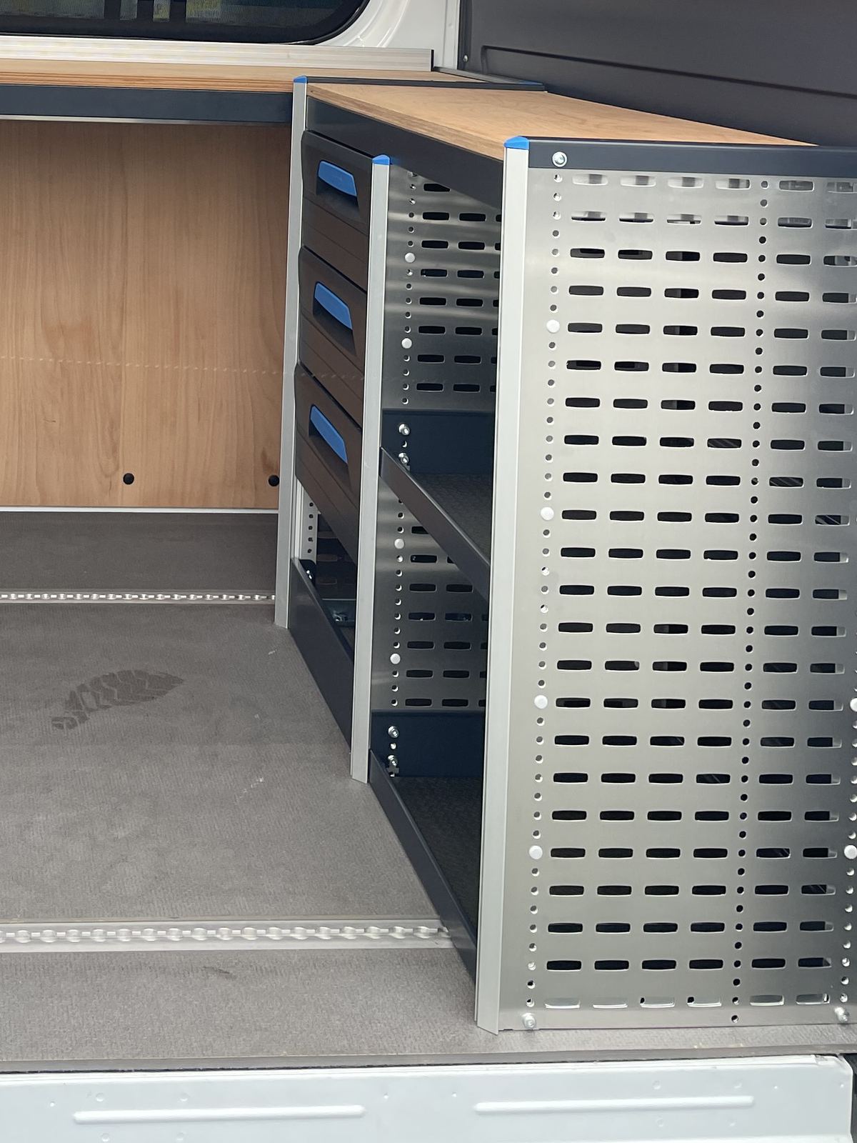 Derselbe Laderaum mit eingebauter Arbeitsplatte, Schubladenblock und Regalsystem